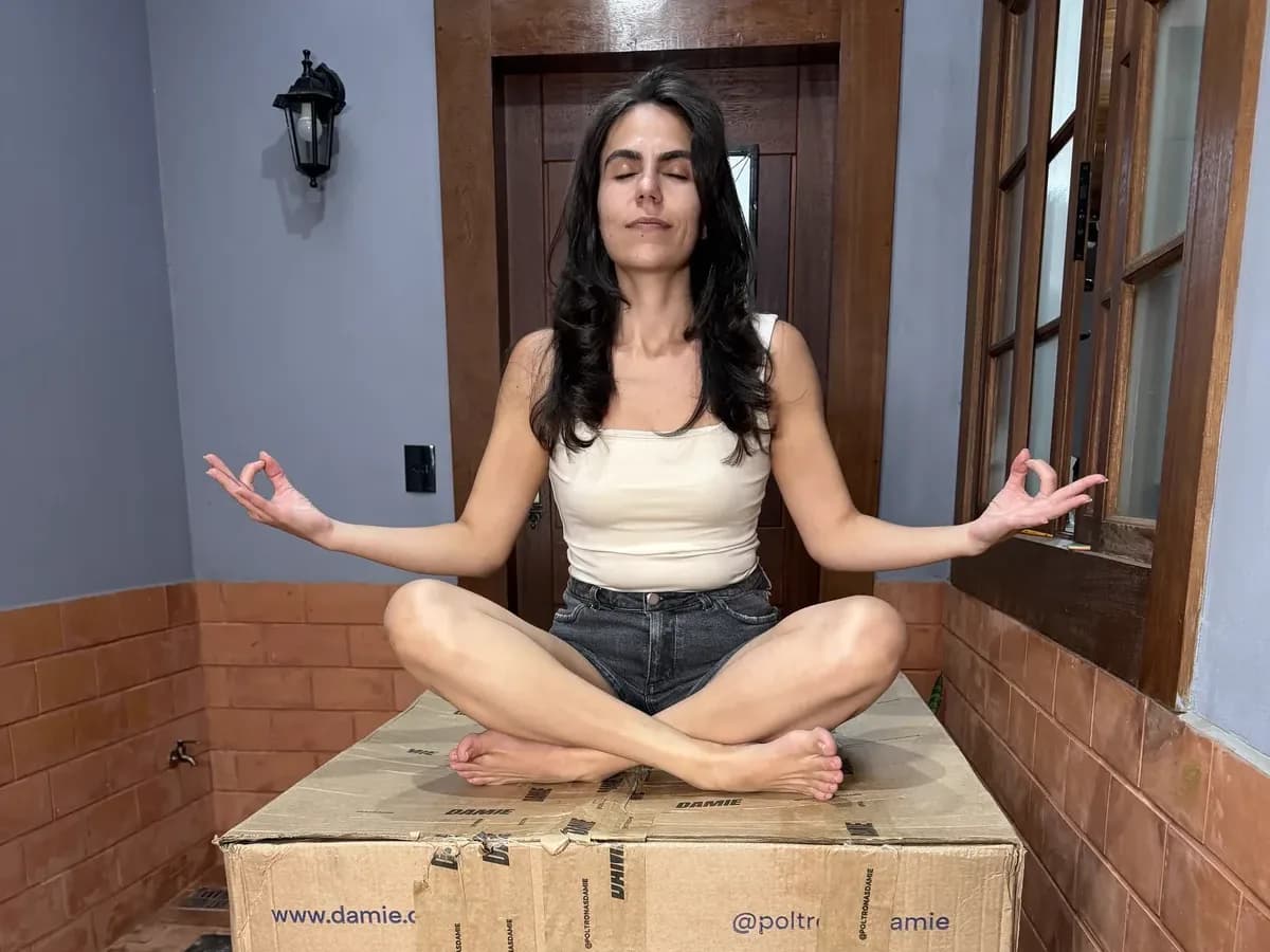 Cecília meditando sobre uma caixa de entrega da Damie