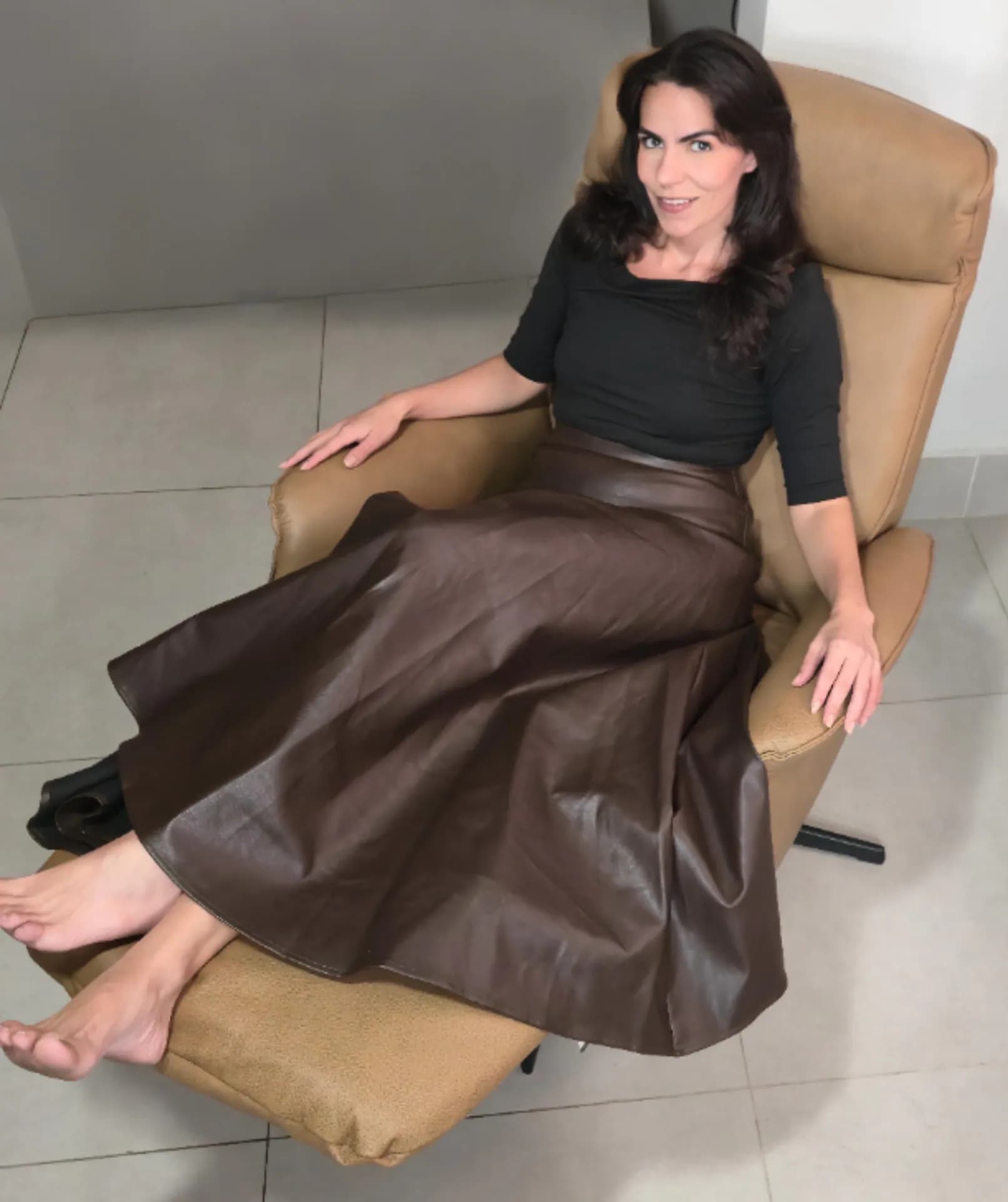 Cecília usando o apoio elevado para as pernas da Poltrona Levita Damie