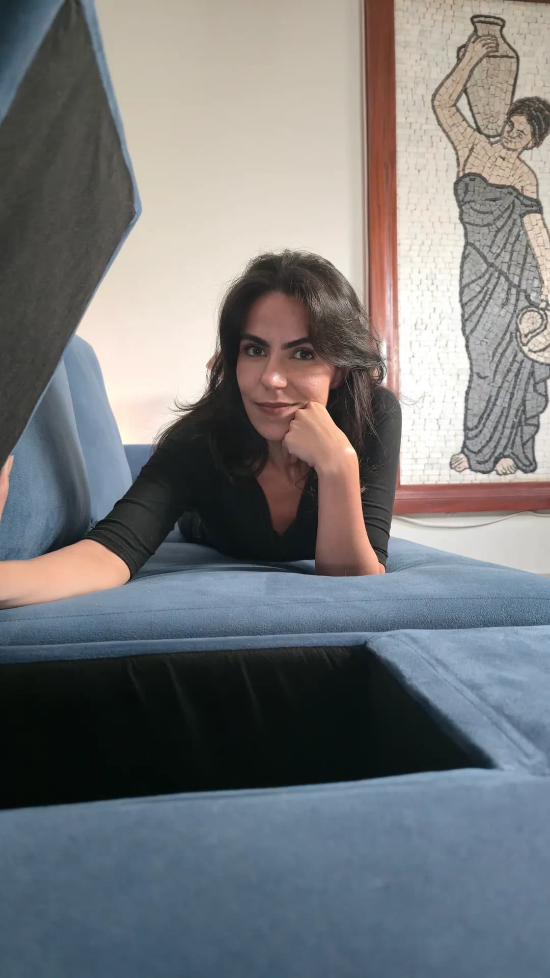 Cecília mostrando o compartimento aberto do módulo com baú do Sofá Modular Damie