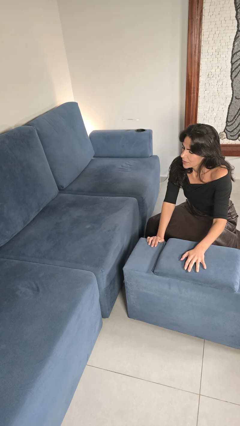Cecília encaixando o puff do Sofá Modular Damie azul durante a montagem